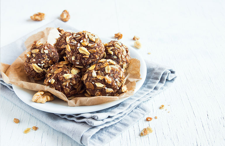 Healthy organic energy granola bites with nuts, cacao, banana and honey - vegan vegetarian raw snack or meal