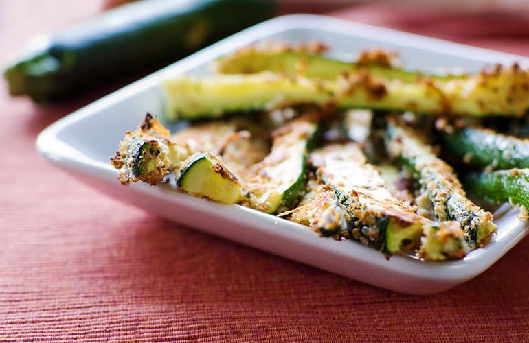 Baked zucchini fries on a white square plate